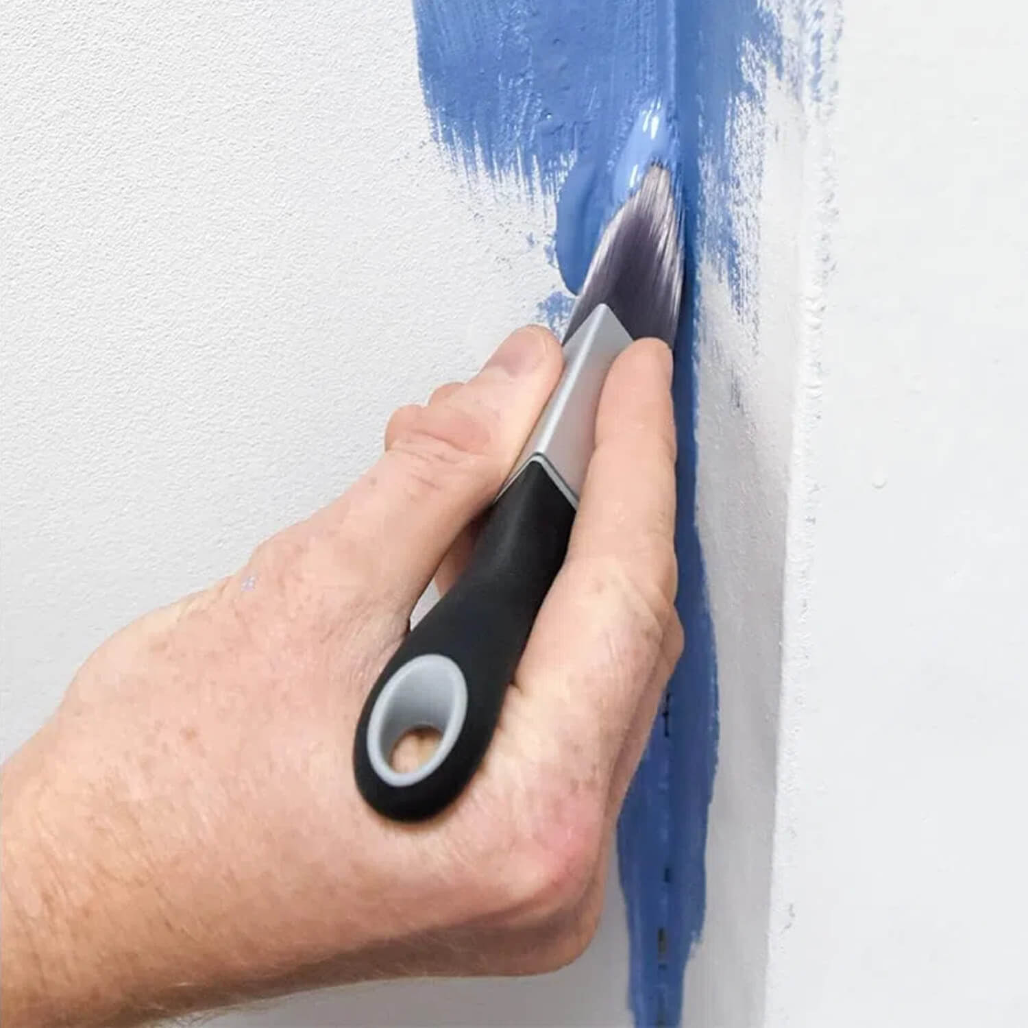 DIY painter using ROLLINGDOG triangle paint brush to paint wall corners with smooth coverage